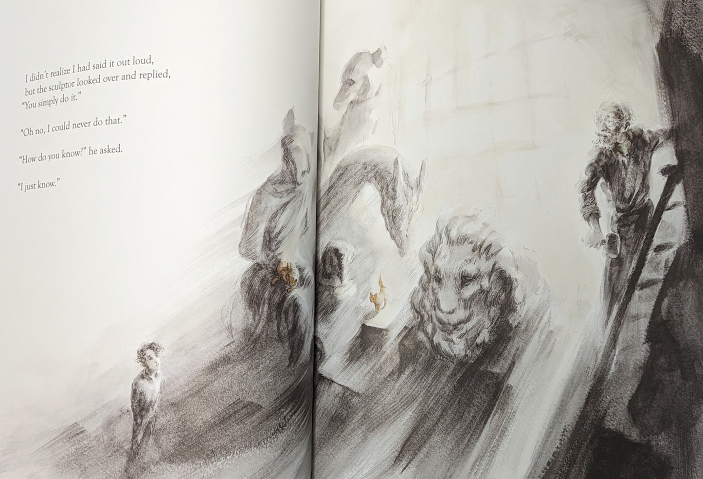 image from storybook of boy talking to sculptor, sculptor's creations like a lions head  is shown, with two orange cats hanging  around