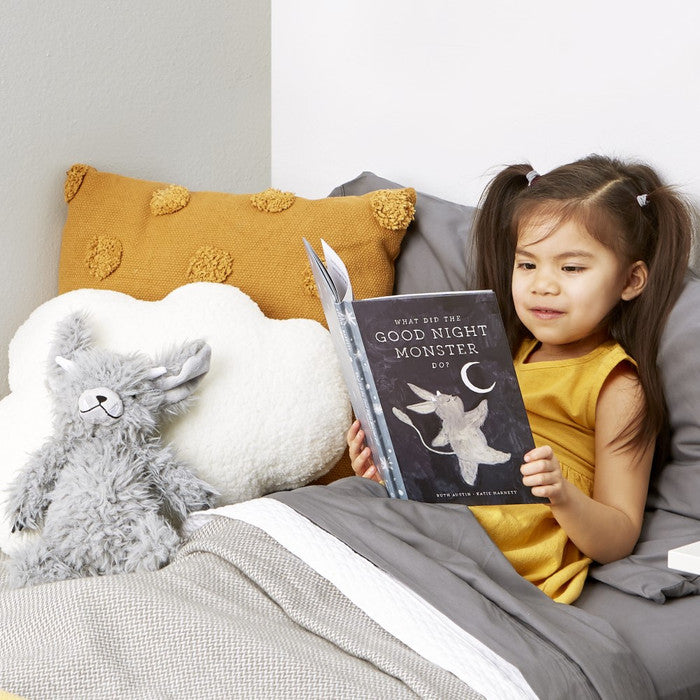 Image of little girl reading Goodnight Monster book in bed with Monster plush